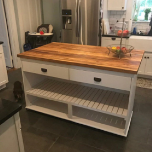 white kitchen island with wood top and fruit stand