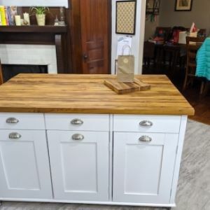 white kitchen island with wood top and bag and cutting board