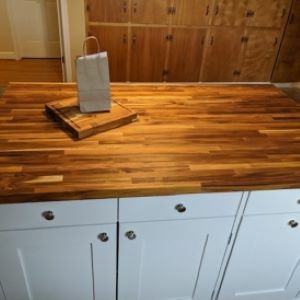 white kitchen island with wood top and bag and cutting board
