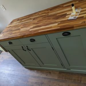 blueish green kitchen island with tood top