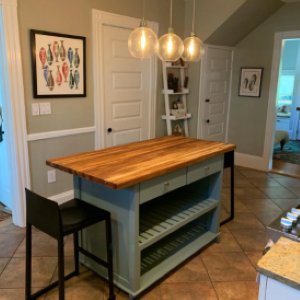 blue kitchen island with wood top and chairs