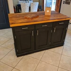 black kitchen island with wood top and bag