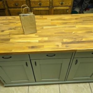 blue-gray kitchen island with wood top and bag