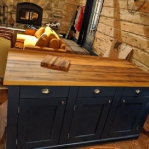 black kitchen island with wood top and bag and cutting board