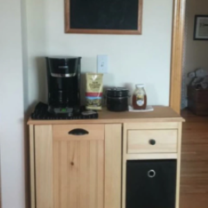 brown trash bin cabinet with coffee items on top