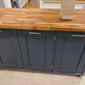 greenish blue kitchen island with wood top and bag