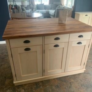 white kitchen island with wood top and bag